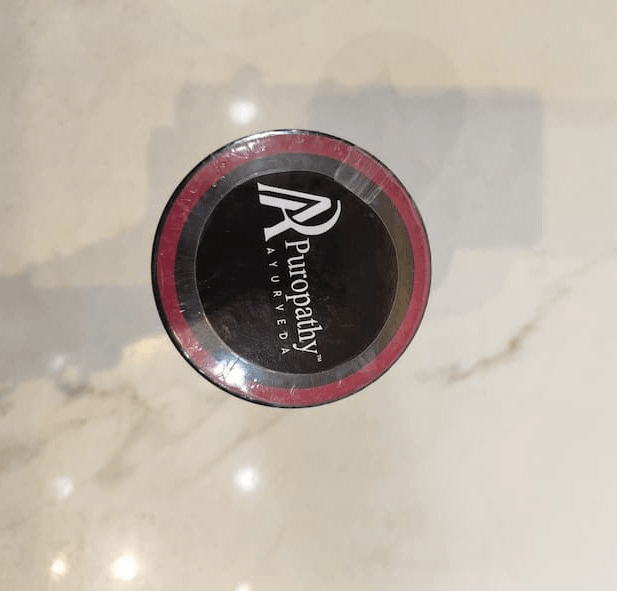 Puropathy Ayurveda Womax supplement container with black and pink branding.